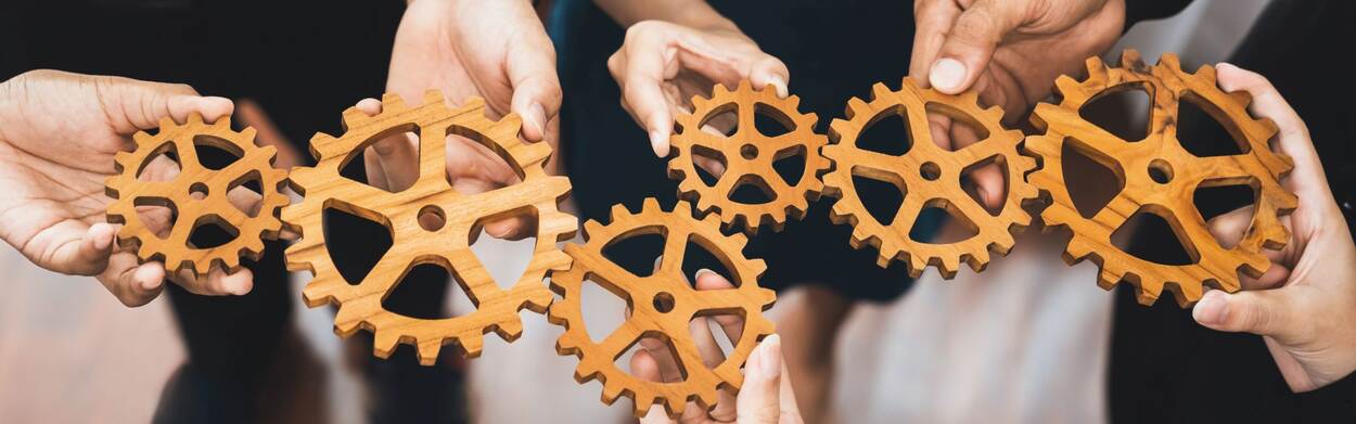 Office worker holding cog wheel as unity and teamwork in corporate workplace concept. Diverse colleague business people showing symbol of visionary system and mechanism for business success. Concord